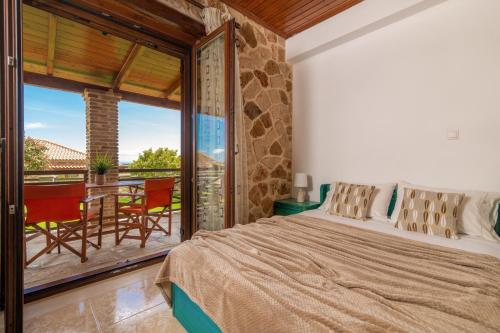 MouzákionVilla La Isla with Private Pool的一间卧室配有一张床,阳台配有桌子