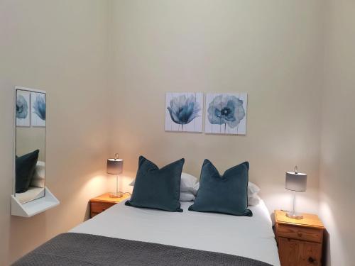 斯特尔拜Muir Holiday Apartments的卧室配有一张挂着蓝色鲜花的床。