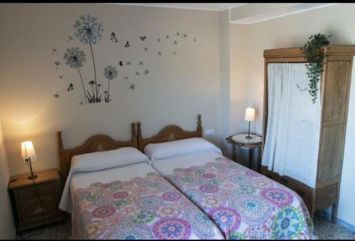 拉瓦纳尔德尔卡米诺LA CASONA DE RABANAL的卧室配有一张墙上鲜花的床