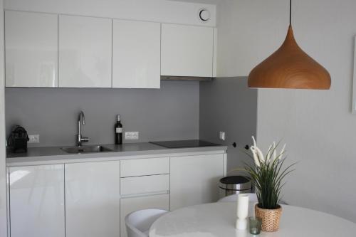 霍勒姆Appartement, Kaap 123 - Ameland的厨房配有白色橱柜和盆栽植物