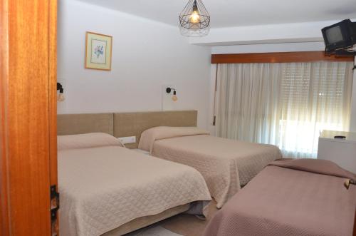菲盖拉-达福什Alojamento Local Manuel da Parreira的一间医院间 - 带两张床和电视