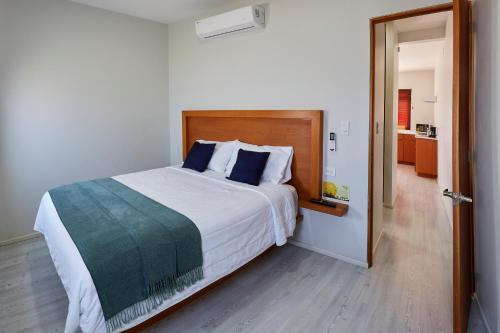 卡波圣卢卡斯Casa Palo Verde的卧室配有带蓝色枕头的大型白色床