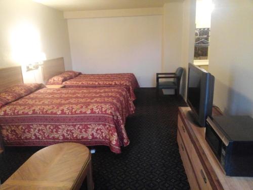 科维纳Evergreen Inn的酒店客房设有两张床和一台平面电视。