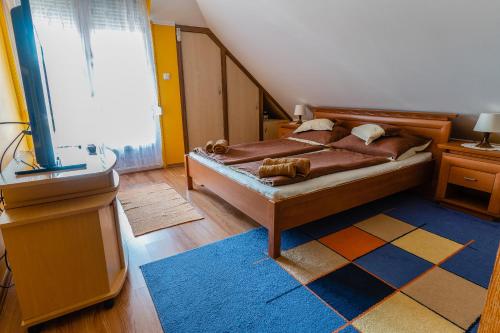 哈卡尼Gál Apartmanház的一间卧室配有一张带地毯的床和窗户