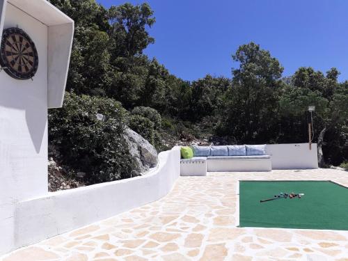 科尔丘拉Relax tiny villas 40 meters of the beach的白色建筑的一边,有绿色目标的钟