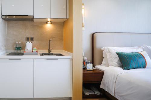 南京南京九龙湖金陵嘉辰酒店（南京南站店）的一间卧室配有一张床,厨房配有水槽