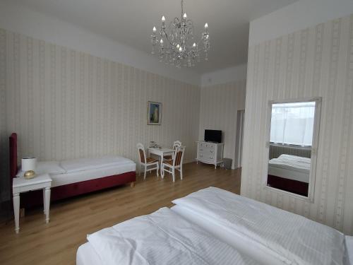 乌拉勒德Liahof的一间卧室配有两张床、一张桌子和一个吊灯。