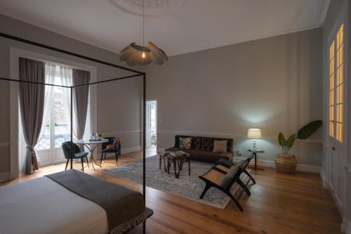 蓬塔德尔加达Casa do Pateo - Charming House Azores的一间卧室设有一张床和一间客厅。