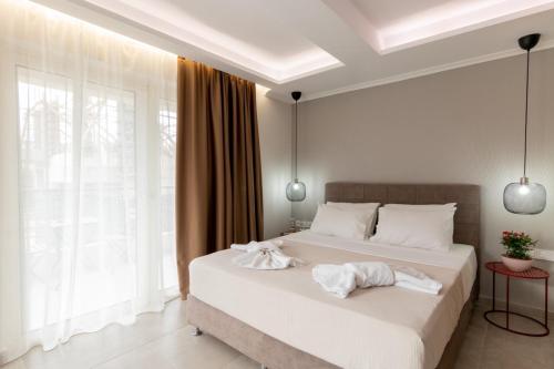 雷夫卡达镇Elite City Apartments & Maisonettes by Imagine Lefkada的一间卧室配有两张床和白色毛巾。