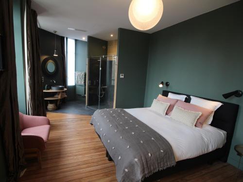 波尔多B&B L'Escapade Bordelaise - Côté Jardin的一间卧室配有一张大床和一张粉红色的椅子