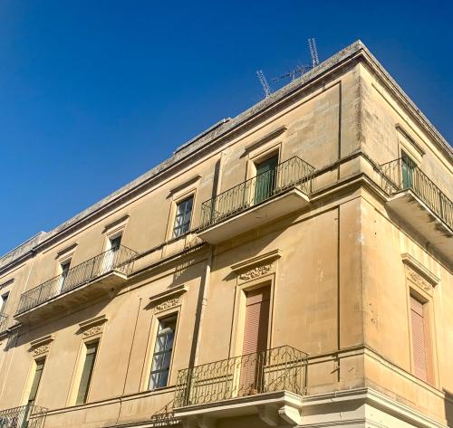 莱切HABITARE Lecce & Salento的带阳台的建筑和蓝天