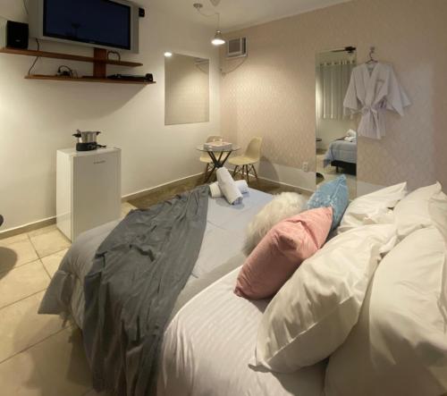伊图佩瓦Hotel ITR-SPA的一间卧室配有带枕头的床和电视。