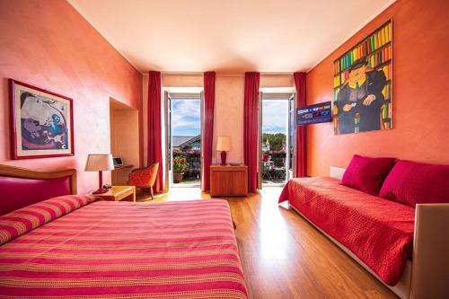 韦尔巴尼亚因特拉酒店的一间卧室配有一张床、一张沙发和窗户。