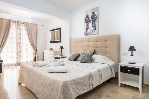 阿德耶处女座别墅的白色卧室设有一张大床和大床头板