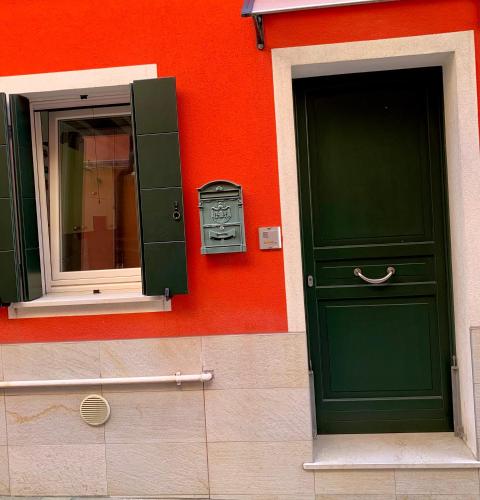 基奥贾Casa Antico Barbiere的一座带绿门和镜子的建筑
