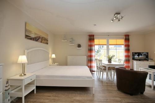 博尔滕哈根Strandvilla Krabbe Wohnung 08的一间带白色床的卧室和一间用餐室