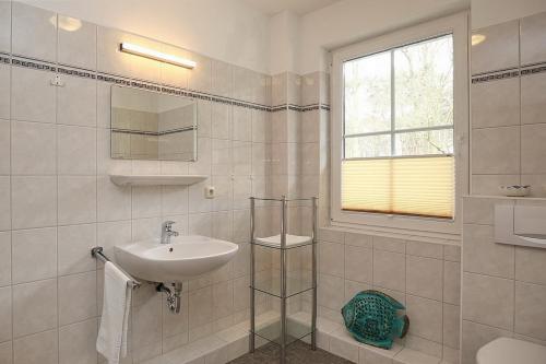 博尔滕哈根Strandvilla Krabbe Wohnung 12的白色的浴室设有水槽和窗户。