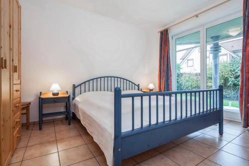 博尔滕哈根Dünenblick Wohnung 19的一间卧室设有一张床和一个大窗户