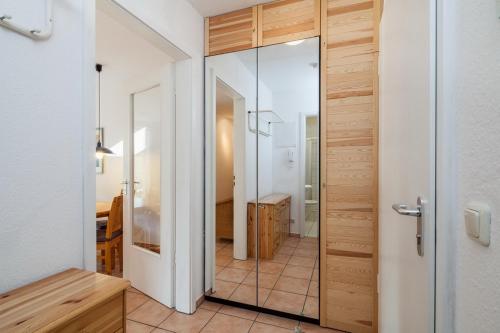 博尔滕哈根Dünenblick Wohnung 19的浴室设有玻璃门,可通往卧室