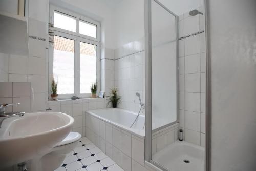 博尔滕哈根Villa Triton Wohnung 01的白色的浴室设有浴缸和水槽。