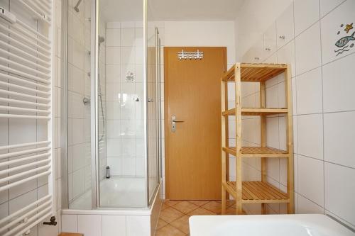 博尔滕哈根Villa Triton Wohnung 05的带淋浴的浴室和玻璃门