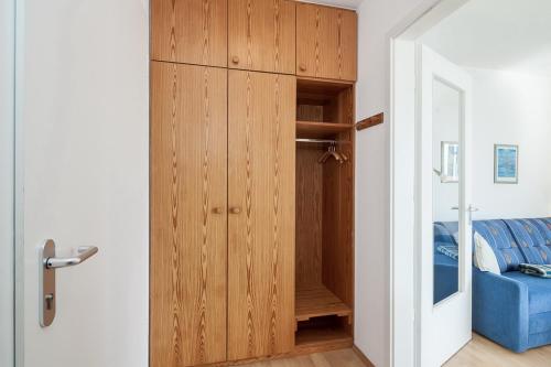 博尔滕哈根Dünenblick Wohnung 17的一个带蓝色沙发的房间内的木制衣柜
