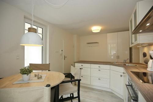 博尔滕哈根Strandvilla Scholle - Lachs Wohnung 01的厨房配有桌子和一些椅子