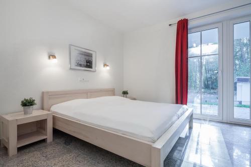 博尔滕哈根Strandvilla Niklot Wohnung 02的白色的卧室设有一张大床和一个窗户