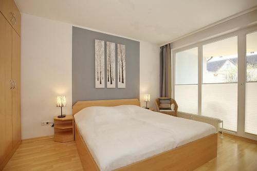 博尔滕哈根Likedeeler Wohnung 13的一间卧室设有一张大床和一个大窗户