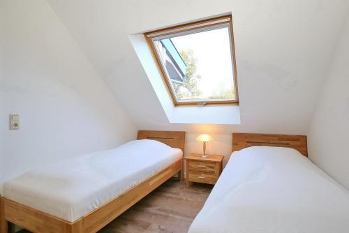 博尔滕哈根Papillon Wohnung 16-7的小型客房 - 带2张床和窗户