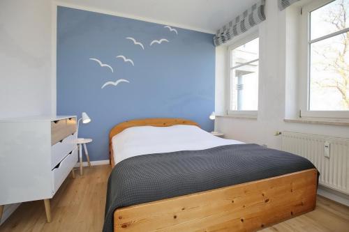 博尔滕哈根Dünenblick Wohnung 12的卧室配有一张墙上鸟床