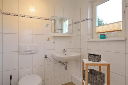 博尔滕哈根Strandvilla Krabbe Wohnung 03的一间带水槽、卫生间和镜子的浴室