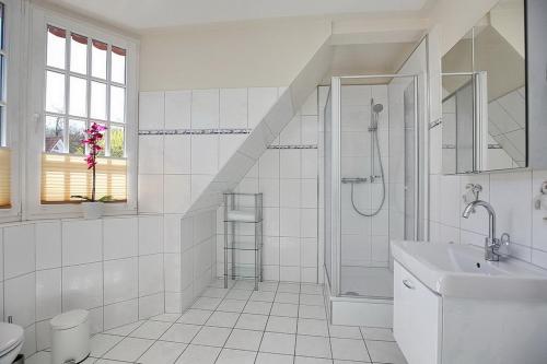 博尔滕哈根Strandvilla Krabbe Wohnung 05的带淋浴和盥洗盆的白色浴室
