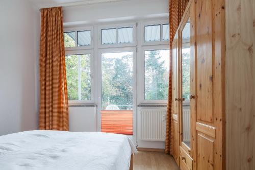 博尔滕哈根Villa Triton Wohnung 02的一间卧室设有一张床和一个大窗户