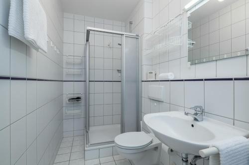 博尔滕哈根Dünenblick Wohnung 24的白色的浴室设有卫生间和水槽。