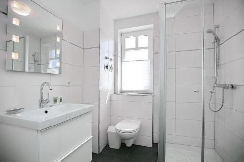 博尔滕哈根Likedeeler Wohnung 12的白色的浴室设有卫生间和水槽。