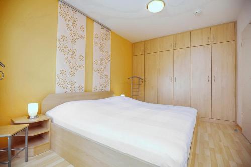 博尔滕哈根Likedeeler Wohnung 12的卧室配有白色的床和木制橱柜。