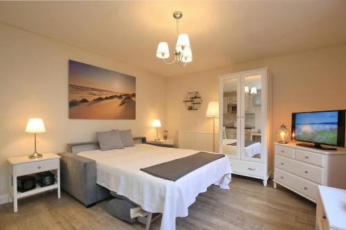 博尔滕哈根Strandvilla Krabbe Wohnung 02的一间卧室配有一张大床和电视