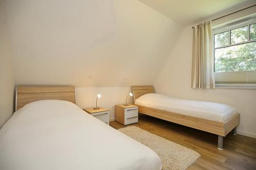 博尔滕哈根Reethaus Am Mariannenweg 17b的配有2张床的小卧室设有窗户