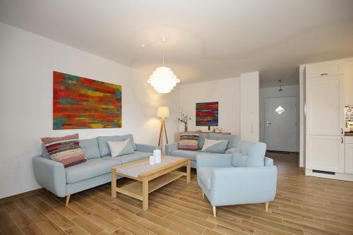 博尔滕哈根Reethaus Am Mariannenweg 02a的客厅配有两张沙发和一张桌子