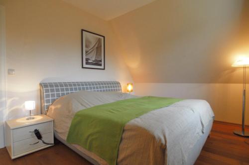 维滕贝克Ferienhaus Hanni的一间卧室配有一张带绿毯的床