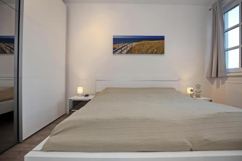海利根达姆Residenz von Flotow Wohnung 18的一间白色卧室,配有一张大床和两张桌子