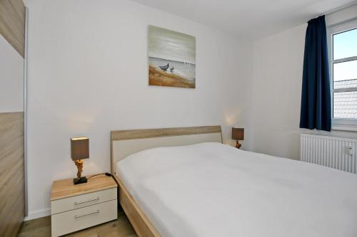海利根达姆Residenz von Flotow Wohnung 15的卧室设有一张白色大床和一扇窗户。