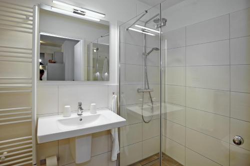 海利根达姆Linden-Palais Wohnung 06的白色的浴室设有水槽和淋浴。