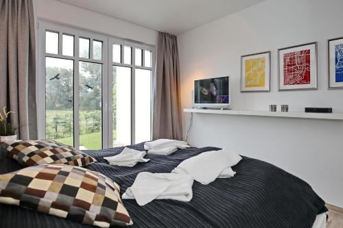 海利根达姆Linden-Palais Wohnung 05的卧室配有带枕头的床铺和窗户。