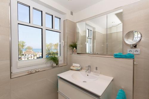 海利根达姆Linden-Palais Wohnung 35的一间带水槽和镜子的浴室以及窗户。
