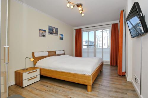 伯尔格伦德-雷特维施Villa Strandvogt Wohnung 11的一间卧室配有一张床和一台电视