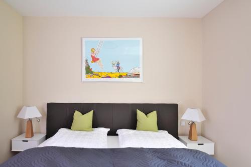 海利根达姆Linden-Palais Wohnung 11的卧室配有一张床,墙上挂有绘画作品
