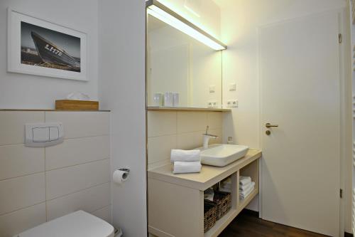 海利根达姆Linden-Palais Wohnung 26的一间带水槽、卫生间和镜子的浴室