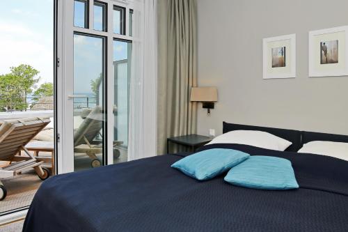 海利根达姆Linden-Palais Wohnung 34的一间卧室配有一张带蓝色枕头的床和一个阳台